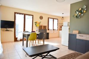 a kitchen and living room with a table and yellow chairs at Terrasse panoramique ensoleillée avec vue mer in Farinole