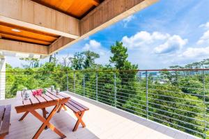 Inbu沖縄の空 海 森を贅沢に独り占めできる森の中の隠れ家的设有一个配有木桌的阳台,享有美景。