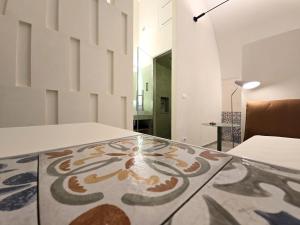 ein Zimmer mit einem Glastisch und einem gemusterten Boden in der Unterkunft Bruni 18 in Fasano