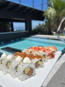 a row of sushi on a table next to a pool at Punta Piana b&b in Palmi