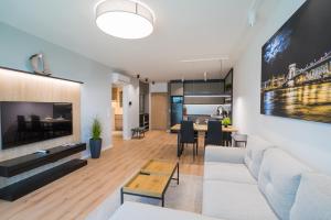 a living room with a white couch and a table at MyFlat Wave Yacht Apartment in Siófok