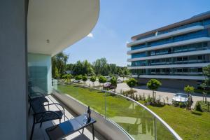 a balcony with a table and chairs and a building at MyFlat Wave Yacht Apartment in Siófok