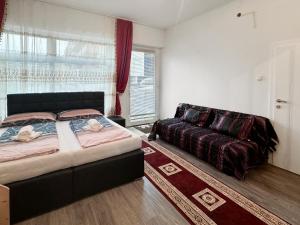 a bedroom with a bed and a couch in it at feworld - city center apartment Villach in Villach