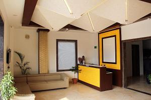 Hotel Taj Heights في آغْرا: غرفة معيشة بسقف ومرآة
