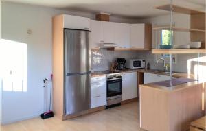 a kitchen with a stainless steel refrigerator and white cabinets at Amazing Home In Väddö With Wifi in Väddö