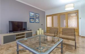 a living room with two chairs and a television at 8 Bedroom Awesome Home In Polop in Polop