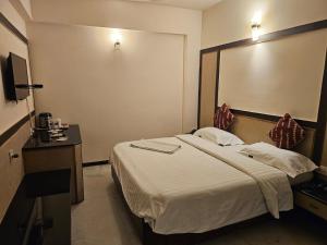 a hotel room with a bed and a large mirror at HOTEL MERILIN in Erode