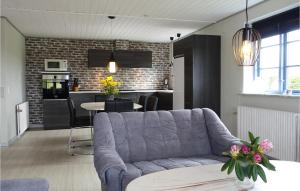 a living room with a couch and a kitchen at Amazing Home In Klemensker With Wifi in Klemensker