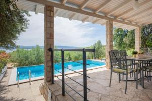 a patio with a table and chairs and a swimming pool at Villas Sole in Bol
