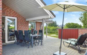 a patio with a table and chairs and an umbrella at Holiday Home Lakolk Iiv Denmark in Bolilmark