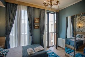 Un dormitorio con una cama y una ventana grande. en Tbilisi center, Nino's Art Apartment, en Tiflis