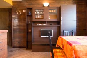 um quarto com uma cama e uma televisão em Ariete Apartments em Livigno