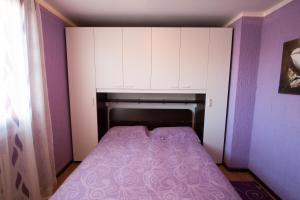 um pequeno quarto com uma cama com paredes e armários roxos em Ariete Apartments em Livigno