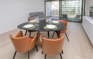 Residentie Crystal في أوستند: غرفة طعام مع طاولة سوداء وكراسي برتقالية