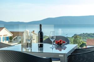 a table with wine glasses and a bowl of fruit at Luxury White Sails Villas with a Multi Sport Court and Sea View in Pinezici
