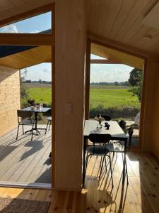 a room with a table and chairs on a deck at 104 Tinyhouse mit Wiesenblick in Bleckede