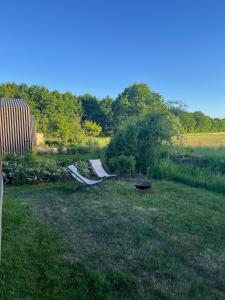two chairs sitting in the grass in a yard at 104 Tinyhouse mit Wiesenblick in Bleckede +16 photos