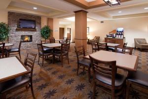 a restaurant with tables and chairs and a fireplace at Holiday Inn Express Hotel & Suites Lamar By IHG in Lamar