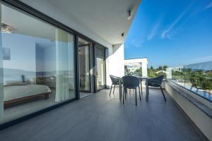 a bedroom with a table and chairs on a balcony at Luxury White Sails Villas with a Multi Sport Court and Sea View in Pinezici