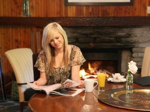 a woman sitting at a table reading a book at The Arrow Hotel in Arrowtown