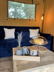 a living room with a blue couch and a table at Teal Safari Tent in Droitwich +7 photos