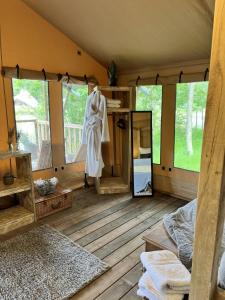 a room with a mirror and a bed in a tent at Teal Safari Tent in Droitwich
