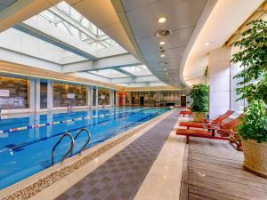 a large swimming pool with a large swimming pool at New Century Hangzhou Grand Hotel in Xiaoshan