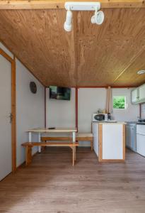 a kitchen with a wooden ceiling and a table at Camping Le Mont Libre - Cottage & espace nature - Gannat in Gannat