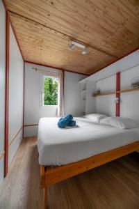 a bedroom with a large bed with a wooden ceiling at Camping Le Mont Libre - Cottage & espace nature - Gannat in Gannat