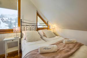 dwa łóżka w pokoju z oknem w obiekcie VisitZakopane- Mallorca Apartment w Zakopanem