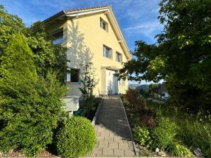 a yellow house with a brick walkway at Villa Modern in Ufhusen