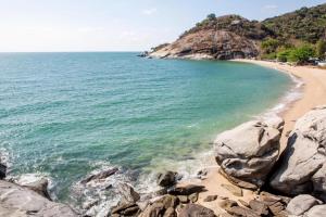a view of a beach with rocks and the ocean at Greenfield Valley Fishing Resort in Hua Hin