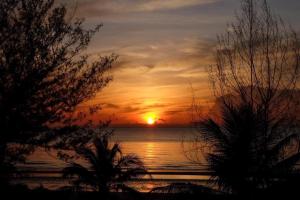 a sunset over the ocean with the sun setting at Greenfield Valley Fishing Resort in Hua Hin +6 photos