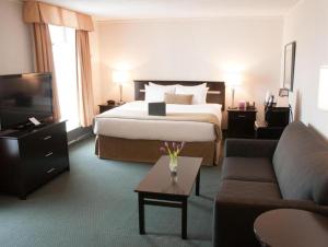 a hotel room with a bed and a couch at Coast High Country Inn in Whitehorse +28 photos