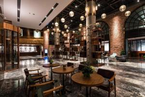 a lobby with tables and chairs and bookshelves at Guilin Plaza Hotel in Guilin