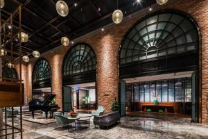 a lobby with a piano and a couch and tables at Guilin Plaza Hotel in Guilin