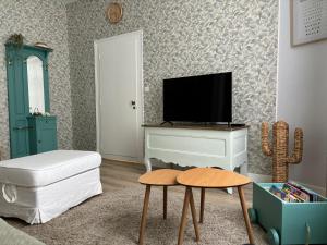 a living room with a tv and a white dresser at La Salle d Attente - Hyper centre in Châlons-en-Champagne