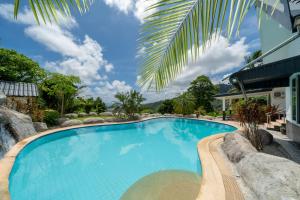 een zwembad in een resort met een palmboom bij Villa Olympus Ocean Vista Kata Beach in Kata Beach