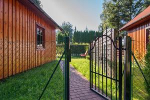 a fence with a gate in front of a house at Posejdon Wydmowa 16 3 in Lubiatowo