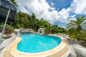 een zwembad in een resort met bomen op de achtergrond bij Villa Olympus Ocean Vista Kata Beach in Kata Beach +84 foto's