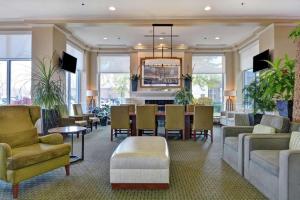 a living room with a table and chairs and a dining room at Hilton Garden Inn Green Bay in Green Bay