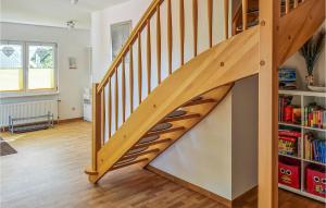 una scala in legno in un soggiorno con una libreria di Beautiful Home In Rukieten With Wifi a Rukieten