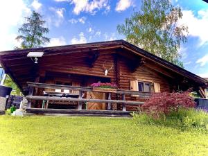una baita di tronchi con portico e fiori alla finestra di Tiroler Blockhaus a Imst