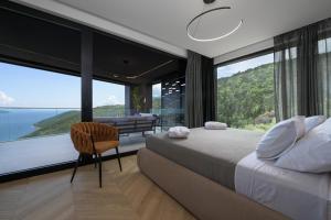 Un dormitorio con una cama grande y una ventana grande. en Villa 3,0 near Opatija for 8 people with indoor and outdoor pool & wellness, en Opatija
