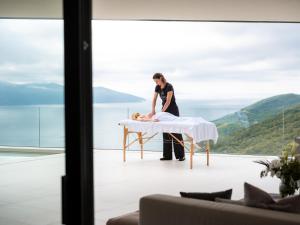 Un hombre de pie junto a una mesa con un perro sobre ella. en Villa 3,0 near Opatija for 8 people with indoor and outdoor pool & wellness, en Opatija