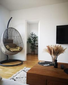 ein Wohnzimmer mit einem Rattanstuhl und einem Tisch in der Unterkunft Appartement proche centre avec parking gratuit in Sèvres