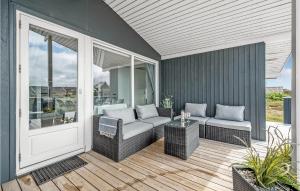 a patio with wicker chairs and a table on a porch at Holiday Home Hvide Sande 31 in Bjerregård
