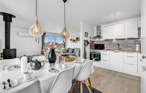 a white kitchen with a table and chairs at Holiday Home Hvide Sande 31 in Bjerregård