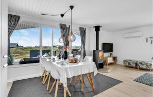 a dining room with a white table with chairs at Holiday Home Hvide Sande 31 in Bjerregård