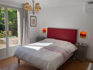 a bedroom with a bed with a red headboard and a window at Les cigales in Saint-Raphaël +16 photos